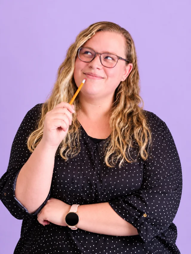 Monique Fourie smiling, tapping a pencil against her chin